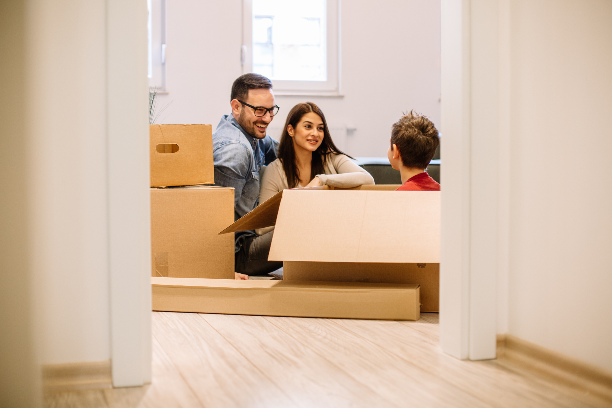 younger white couple talking-smiling to son sitting in box