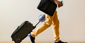 person from waist down walking with luggage