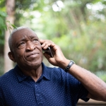 older african american male listening to mobile phone with expression of concern